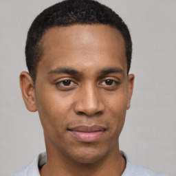 Joyful black young-adult male with short  brown hair and brown eyes