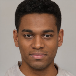 Joyful black young-adult male with short  brown hair and brown eyes