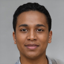 Joyful black young-adult male with short  black hair and brown eyes